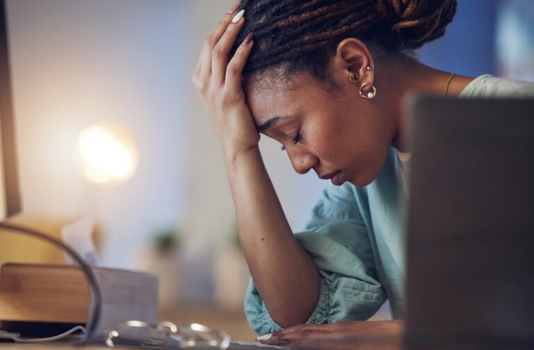 business woman holding her head and closing her eyes, feeling depressed
