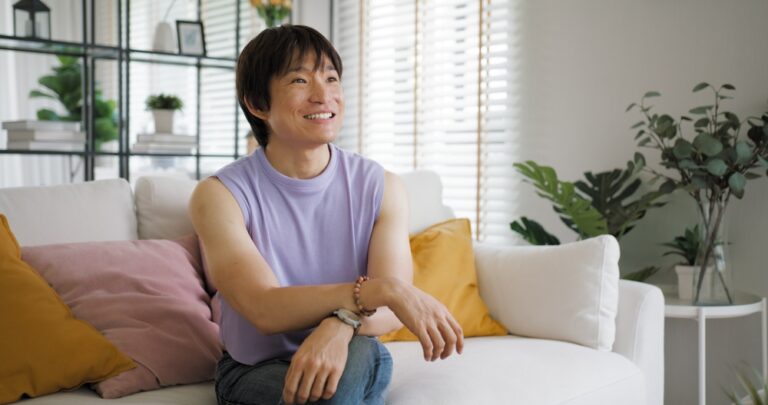 Asian man sitting in therapy with a smile on his face